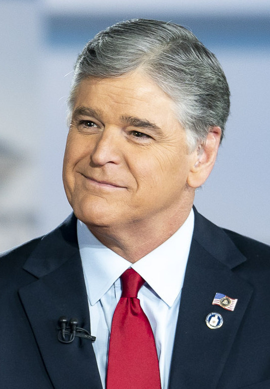 A real human broadcaster at an anchor desk, shown in place of the sleeping cat host